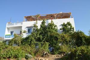 un bâtiment blanc avec des arbres devant lui dans l'établissement Ali Baba complete Apartment Hostel 8Person, à Chefchaouen