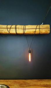 a light bulb hanging from a wooden beam at #Pobega heritage - self check-in in Timişoara
