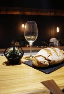 a glass of wine and a loaf of bread on a table at #Pobega heritage - self check-in in Timişoara