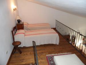 1 Schlafzimmer mit 2 Betten und einer Treppe in der Unterkunft Appartamento TRE QUERCE di Guerrini Gian Carlo in Sorano