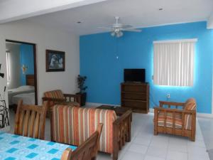 sala de estar con paredes azules, mesa y sillas en Inmobiliaria Percales en Veracruz