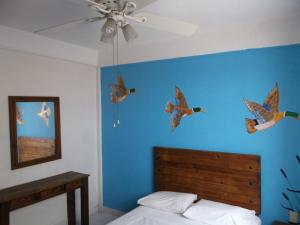 a bedroom with a blue wall with birds on the wall at Inmobiliaria Percales in Veracruz