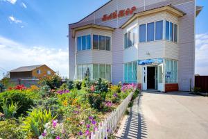a building with flowers in front of it at Baytor Guest House in Karakol