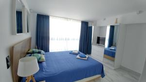 a bedroom with a blue bed and a large window at OpenSky Lux in Kallithea Halkidikis +34 photos