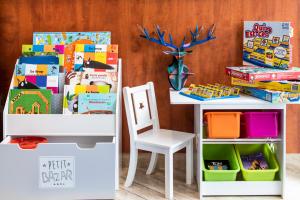 a table and a chair next to a book shelf at Aparthotel Adagio Muenchen City in Munich