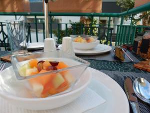 a bowl of fruit on a white plate on a table at Maartens Guesthouse in Cape Town +31 photos