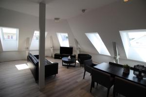 ein Wohnzimmer mit Stühlen, Tischen und Fenstern in der Unterkunft KRSferie leiligheter i sentrum in Kristiansand