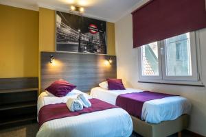 a hotel room with two beds with towels on them at Flandria Hotel in Ghent