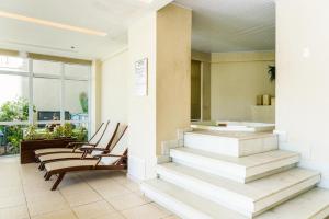 una hall con sedie e scale in un edificio di Mandai Flat Hotel a Cabo Frio