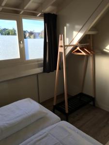 a bedroom with a ladder and a bed and a window at Studio de Pelgrim in Vrouwenpolder