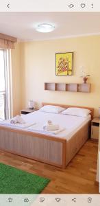 a large bed in a bedroom with a green rug at Olimp Lux in Budva