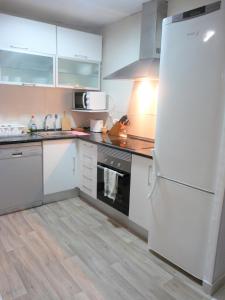 eine Küche mit einem weißen Kühlschrank und einer Spüle in der Unterkunft Day Ok Beach Apartment in Malgrat de Mar