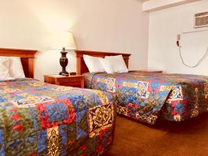 two beds sitting next to each other in a hotel room at North Country American Inn in Kalkaska