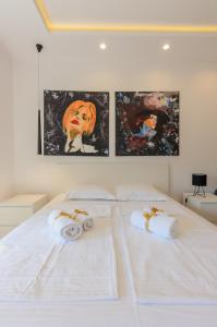 um quarto com duas camas brancas com arte na parede em Sava Smart Apartment em Belgrado