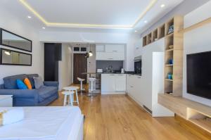 a living room with a blue couch and a kitchen at Sava Smart Apartment in Belgrade