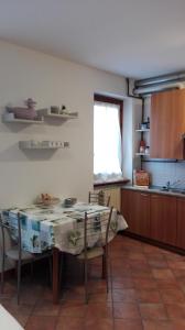 eine Küche mit einem Tisch und Stühlen sowie einem Fenster in der Unterkunft Sweet Home Casa Vacanze "La Terrazza" in Rovetta