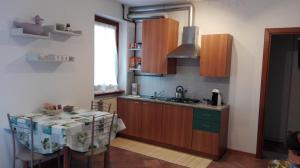 a kitchen with a table and a sink and a counter at Sweet Home Casa Vacanze "La Terrazza" in Rovetta +8 photos