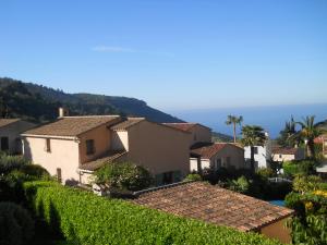a row of houses on a hill with the ocean in the background at STUDIO INDEPENDANT LA TURBIE in La Turbie