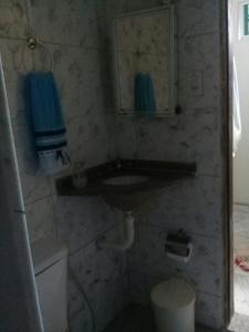 y baño con lavabo, espejo y aseo. en Diária em Família, en Natal