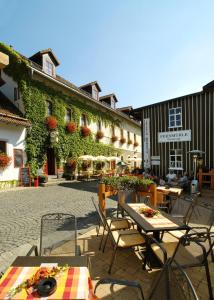 eine Terrasse mit Tischen und Stühlen vor einem Gebäude in der Unterkunft Hotel Zur Fernmühle in Ziegenrück