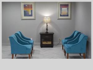 two blue chairs in a room with a lamp at Clarion Pointe Indianapolis Northeast in Castleton