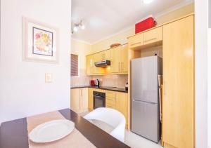 a kitchen with a table and a refrigerator at Bougain Villas in Cape Town