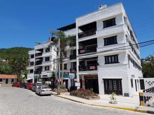 un edificio blanco al lado de una calle en Apartamento com Vista ao Mar, en Bombinhas