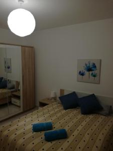 No8 @ Seabreeze Court في مليحة: غرفة نوم عليها سرير ومخدات زرقاء