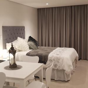 a bedroom with a bed and a table and chairs at No 2 Heleza Blvd Sibaya, Oceandune, Umhlanga Durban in Umdloti +41 photos