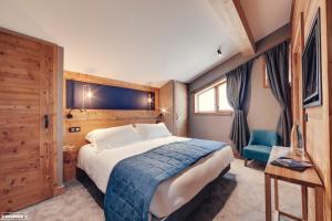 a hotel room with a bed and a blue chair at Hôtel Avancher in Val-d'Isère +114 photos