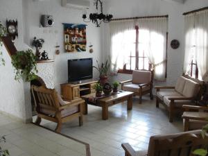 uma sala de estar cheia de mobiliário e uma televisão de ecrã plano em Hotel Colonial em San Bernardo