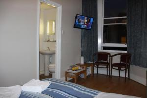 een hotelkamer met een bed en een tv aan de muur bij Ambassador Hotel in Brighton & Hove +108 foto's