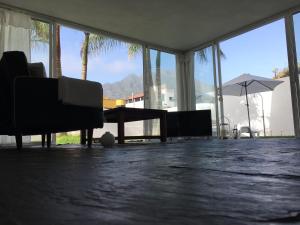 a living room with chairs and a table and windows at White House Suite in Los Llanos de Aridane