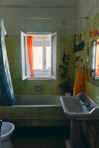 baño con bañera, lavabo y ventana en Tetouan house, en Tetuán