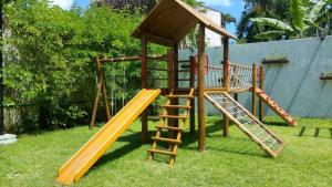 um parque infantil com dois escorregas e uma estrutura de jogos de madeira em Casa Condominio Fechado Total Segurança - Juquehy em Juquei
