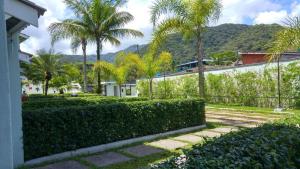a house with palm trees and a train in the background at Casa Condominio Fechado Total Segurança - Juquehy in Juquei