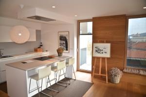 a kitchen with a island with bar stools at i Design Apartment in Ljubljana