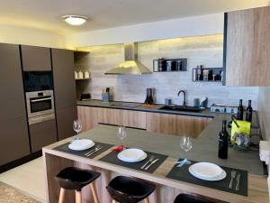 a kitchen with a table with plates and glasses on it at Los Cristianos Best Beach View in Arona