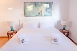 リスボンにあるALTIDO Graca Luminous 2-BR Apartment with Terraceのベッドルーム1室(白いベッド1台、ランプ2つ付)