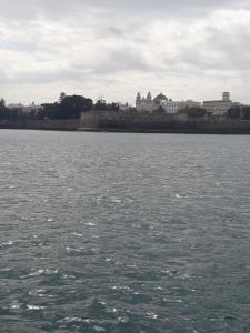a large body of water with a city in the background at Hostal Centro Sol in Cádiz
