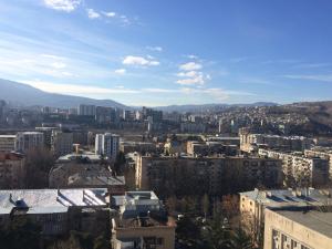 a view of a city with buildings and mountains at Studio Cosy MM in Tbilisi City