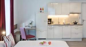 a kitchen with white cabinets and a table with a plate of fruit at Villa Caldarum in Caldaro +4 photos