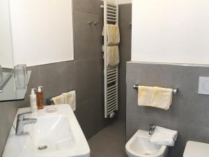 a bathroom with a white sink and a toilet at Villa Caldarum in Caldaro