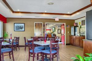 a restaurant with tables and chairs and a kitchen at Hometown Inn Thomasville in Thomasville