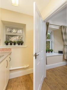 an open door to a kitchen with potted plants on a window at Poppy's Place Cupar in Cupar