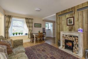 a living room with a fireplace and a table at Poppy's Place Cupar in Cupar