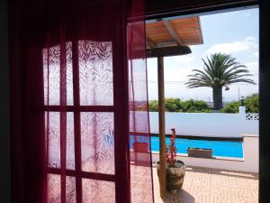 a window with a view of a swimming pool at Casa Andres in La Asomada