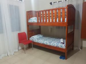 a bedroom with two bunk beds and a red chair at Family Friendly Stay near Entebbe Airport in Entebbe