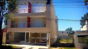 a large white building with red stripes on it at Apartamento in Villa Elisa