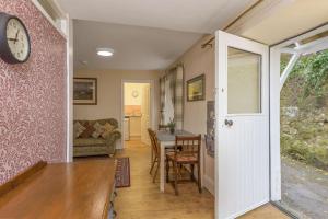 a living room with a table and a clock on a wall at Poppy's Place Cupar in Cupar